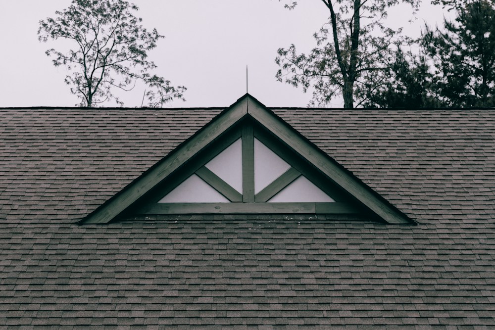 A finished shingle roof with a gable vent
